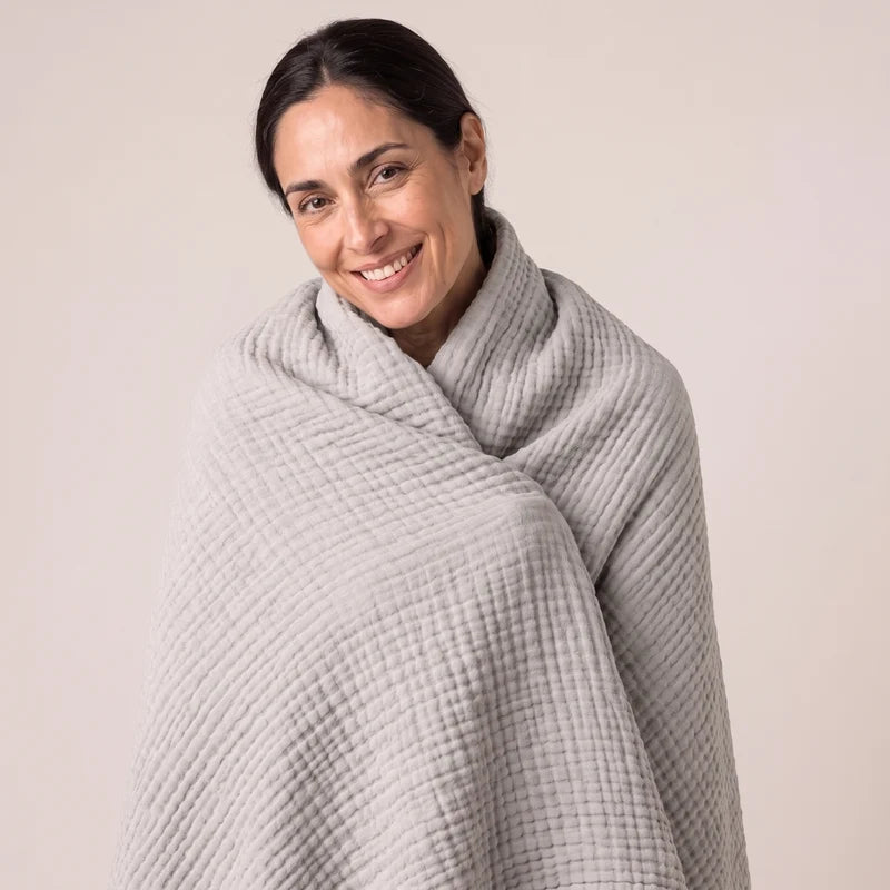 Woman wearing the Muslin Blanket in Grey draped over both shoulders